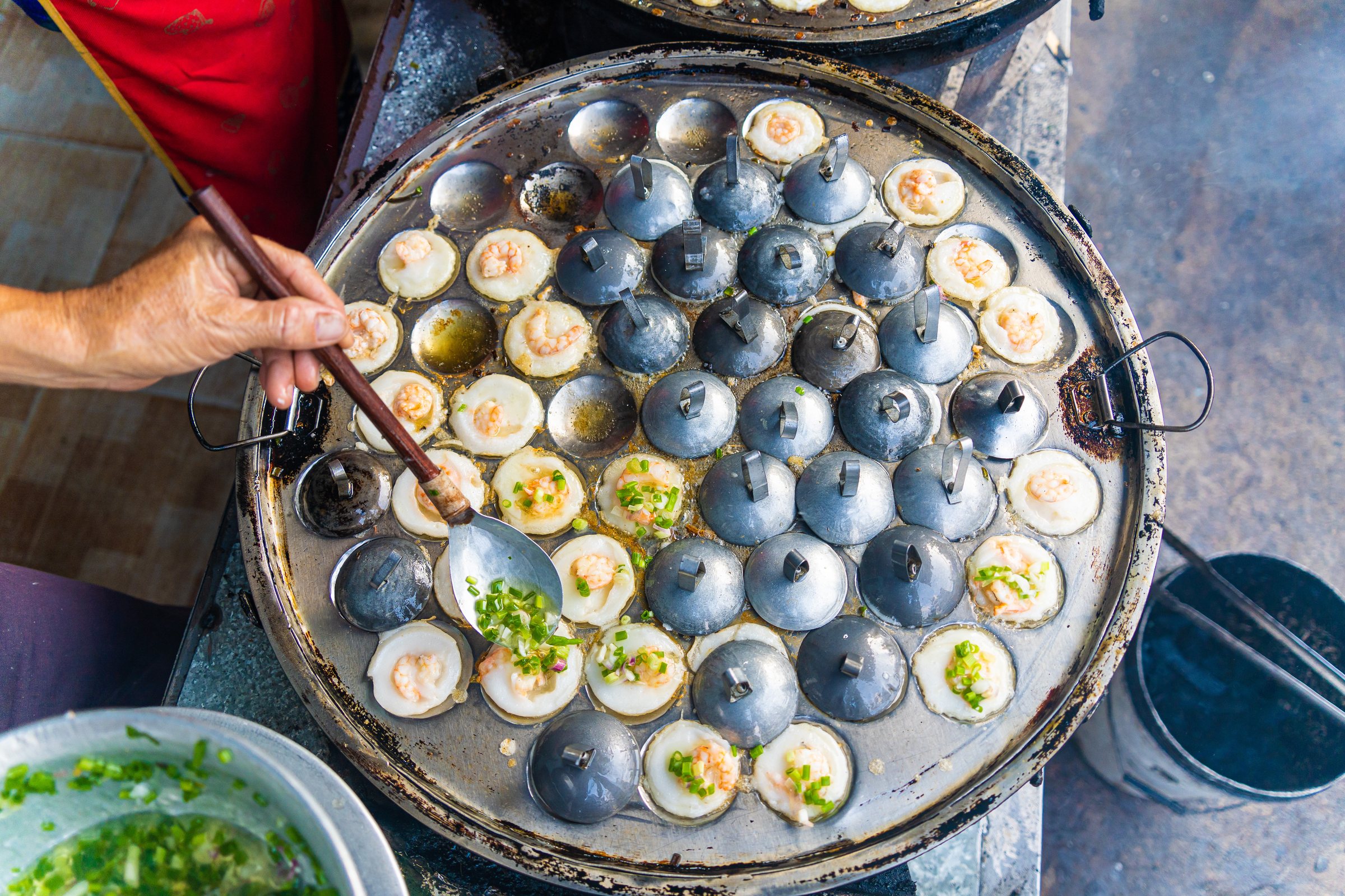 Vietnamese savory mini shrimp pancakes (Banh Khot) with herbs, eggs, shrimps and fish Sauce - Vietnamese cuisine.