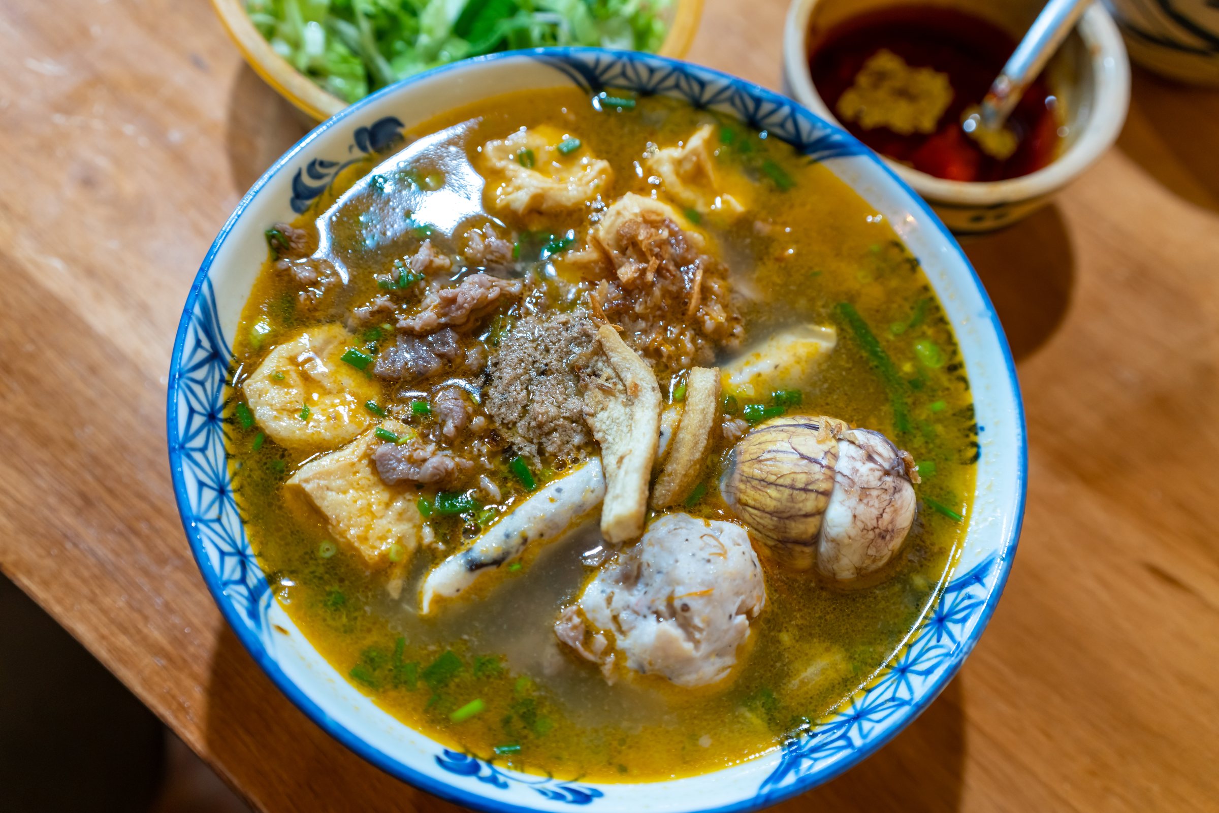 Vietnam traditional street food bun rieu cua crab rice noodle soup bowl with pork foot, blood cake and tofu