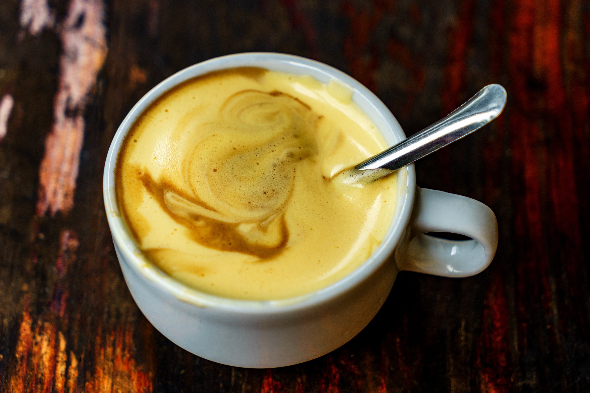 Top view a cup of Giang egg coffee on wood background. Vietnamese coffee in Ha Noi, Vietnam. Eggs are beaten with coffee, hot drink or with ice
