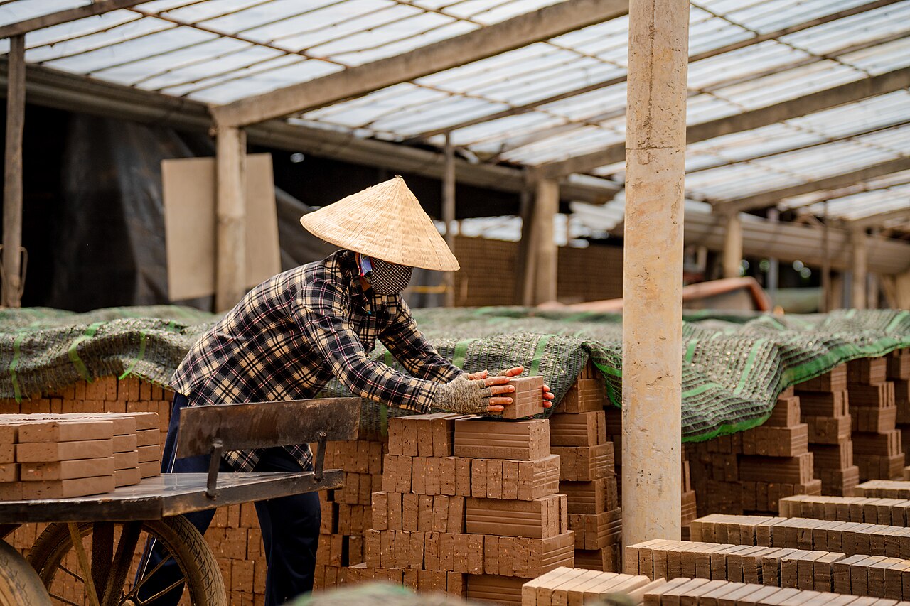 A woman is drying bricks in the sun in Vinh Long, Vietnam